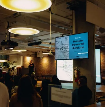 a man standing in front of a projection screen